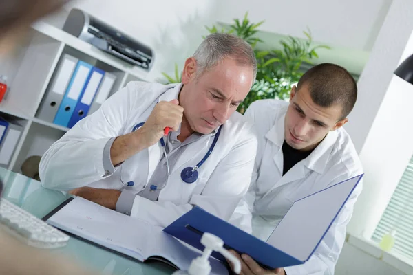 Apprentice Doctor Checking Patients Folder — Foto Stock