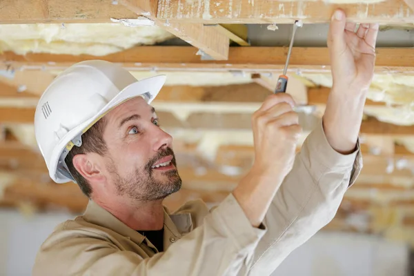 Male Builder Using Screwdriver Wooden Beam — Stockfoto