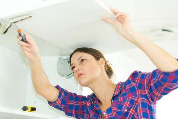 Woman Fitting Overhead Cupboard Kitchen — Fotografia de Stock