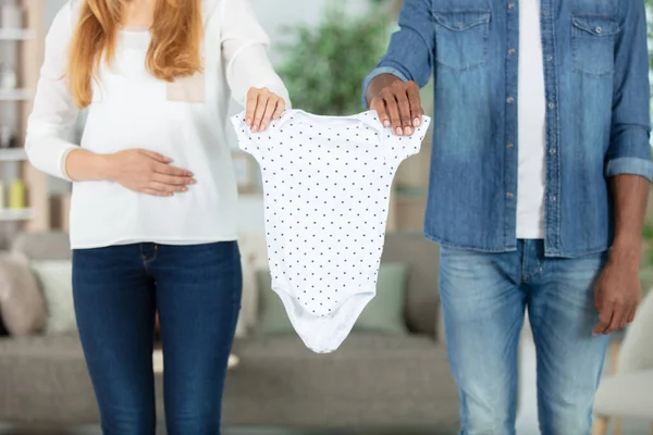 Couple Holding Baby Clothes Together — Foto de Stock