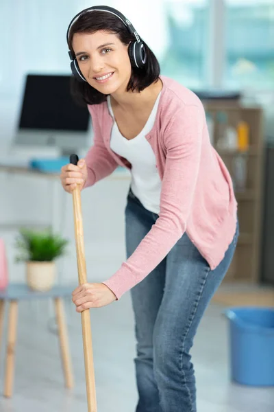 Woman Mopping Floor Wearing Cordless Headphones — стоковое фото