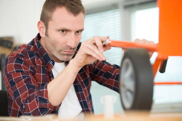 Man Fixing Caster Roller Wheel — 图库照片