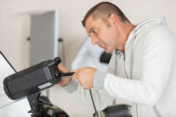 Photographer Prepares Flash Unit Studio Light — стоковое фото