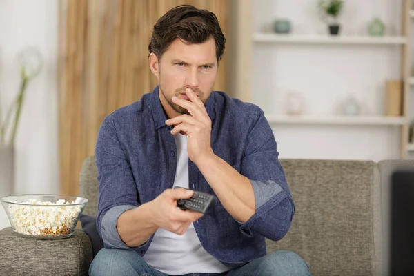 Contemplative Man Holding Remote Control — Stok fotoğraf