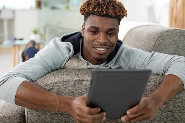 Young Hipster Laying Sofa Using Tablet — Foto de Stock
