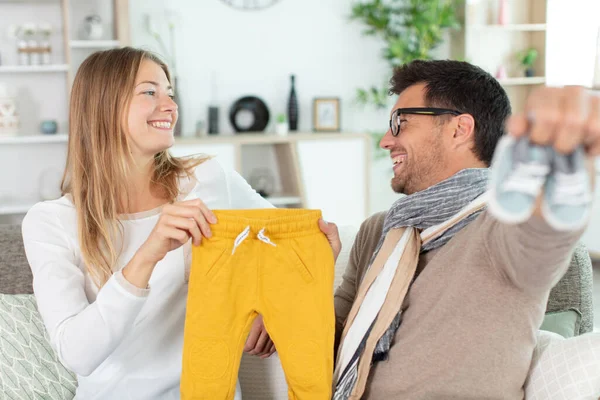 Coppia Felice Che Tiene Vestiti Bambini — Foto Stock