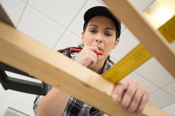 Vrouw Kijkt Verward Tijdens Het Meten Van Hout — Stockfoto