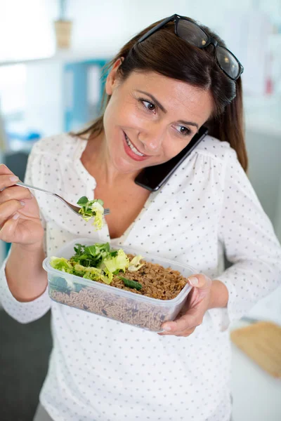 Vrouw Eten Verpakt Lunch Met Telefoon Evenwichtig Haar Schouder — Stockfoto