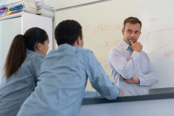 Profesor Por Pizarra Mirando Pensativamente Los Estudiantes —  Fotos de Stock