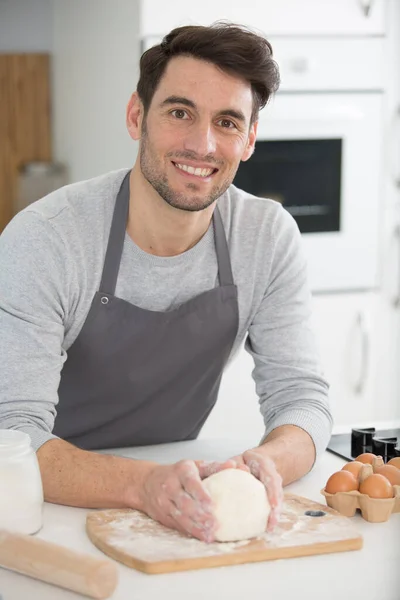 Χαμογελαστός Άνδρας Ποδιά Κατά Την Προετοιμασία Ζύμης Στην Κουζίνα — Φωτογραφία Αρχείου
