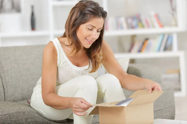 Sorrindo Mulher Abrindo Caixa Papelão Casa — Fotografia de Stock