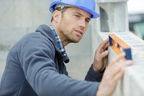 Worker Blue Uniform Measures Wall Level — Stock Photo, Image
