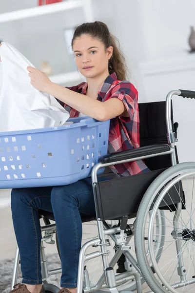 Kadın Tekerlekli Sandalyede Çamaşır Makinesine Çamaşır Koyuyor — Stok fotoğraf