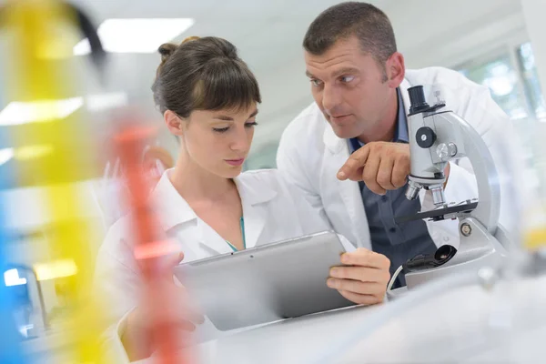 남자와 여자는 실험실에서 태블릿을 사용하고 있습니다 — 스톡 사진