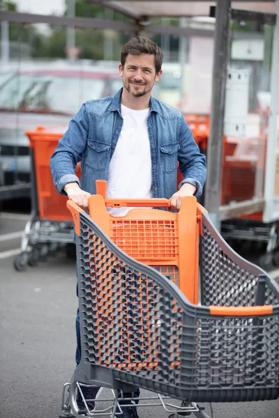 Knappe Man Met Een Winkelwagentje Een Parkeerplaats — Stockfoto