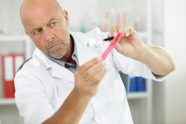 Mature Scientist Checking Reagent Test Tube — Stock Photo, Image