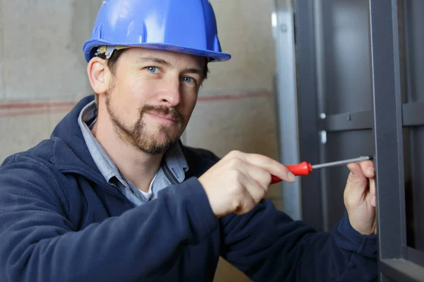 Young Man Screws Screwdriver Frame — Stock Photo, Image