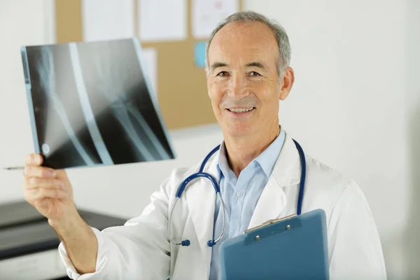 Médico Senior Mirando Rayos Consultorio —  Fotos de Stock