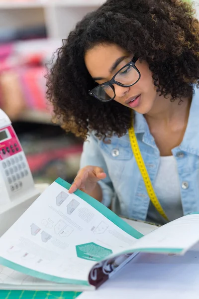 Vrouw Zoek Door Instructieboek Voor Elektronische Naaimachine — Stockfoto