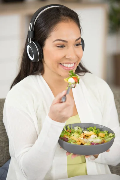 Mujer Feliz Usando Auriculares Comiendo Ensalada —  Fotos de Stock