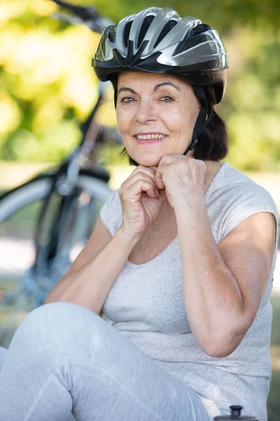 Aktive Seniorin Sichert Ihren Fahrradhelm — Stockfoto