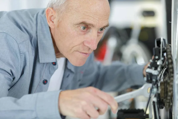 Senior Man Die Fietswiel Repareert — Stockfoto