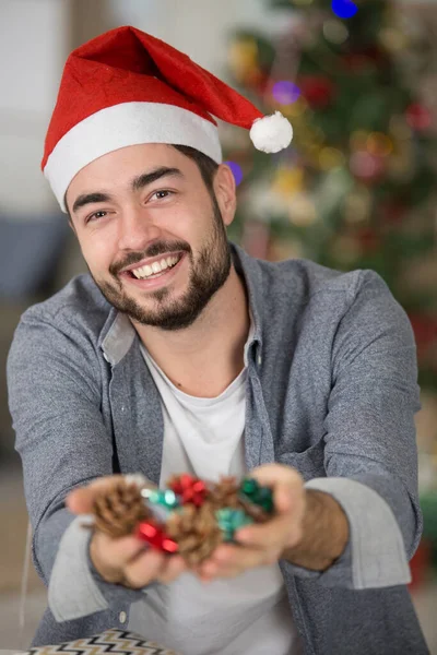 Young Happy Man Shows Christmas Decorations — Stock Photo, Image