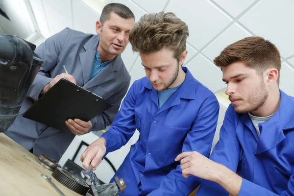 Nauczyciel Pomaga Uczniom Szkolenia Mechaników Samochodowych — Zdjęcie stockowe