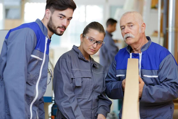 Senior Timmerman Met Studenten Die Kwaliteit Van Hout Onderzoeken — Stockfoto