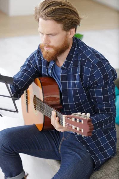 Homem Bonito Tocando Guitarra Enquanto Sentado Sala Estar Luz — Fotografia de Stock