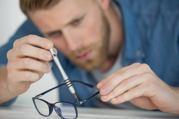 Hombre Sostiene Sus Gafas Sus Manos —  Fotos de Stock