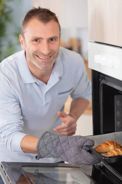 Gelukkig Man Bakken Croissants Oven Binnen — Stockfoto