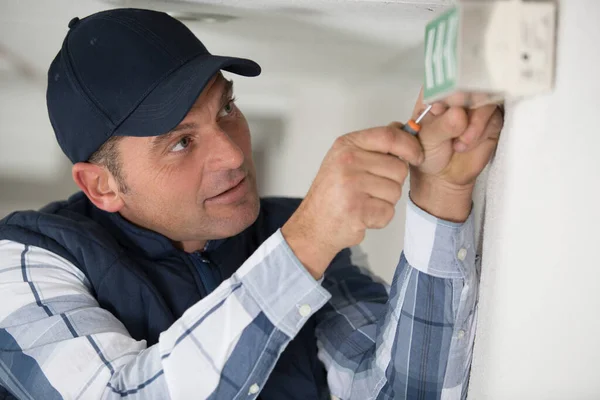 Homem Fixando Sinal Saída Para Parede — Fotografia de Stock