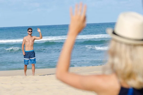 Zorgeloze Jonge Vrouw Zwaaien Naar Vriendje Buurt Van Zee — Stockfoto