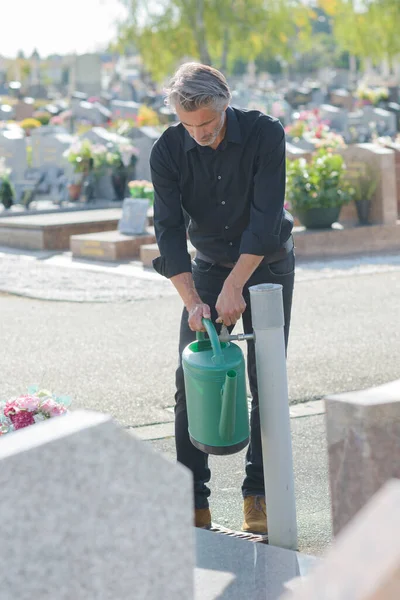 Uomo Che Raccoglie Acqua Nel Cimitero — Foto Stock