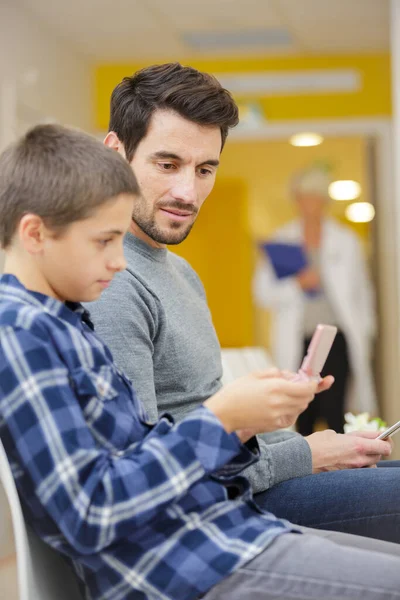 Sorrindo Pai Filho Sentados Esperando Por Médico Hospital — Fotografia de Stock