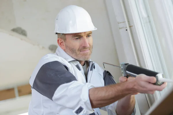 Arbetare Som Använder Ett Silikonrör För Reparation Fönster Inomhus — Stockfoto