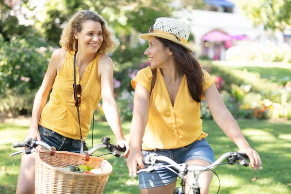 两个骑自行车的女性朋友在户外笑着 — 图库照片