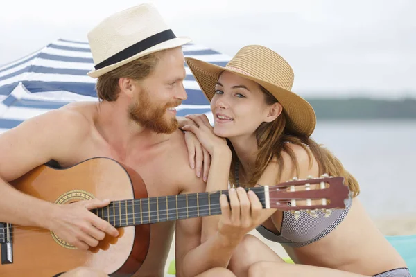 ボーイフレンドがビーチでギターを弾く — ストック写真
