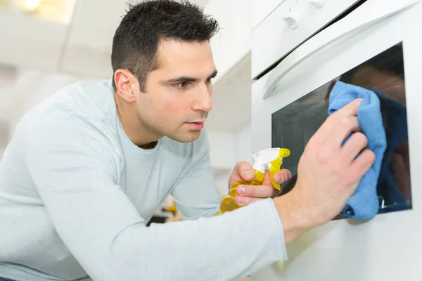 Man Wiping Oven Glass — Stock Photo, Image