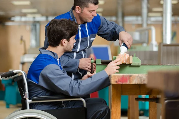 工場の車椅子で働く指導者や障害者は — ストック写真