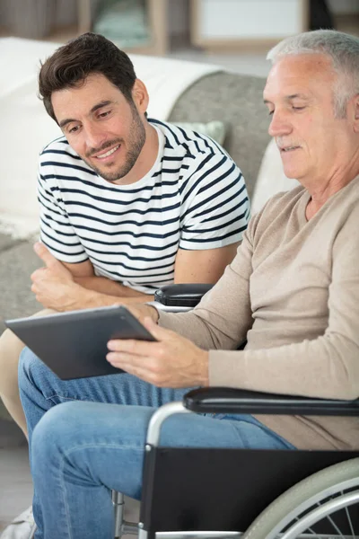 Homem Adulto Olhando Para Tablet Com Seu Pai Mais Velho — Fotografia de Stock