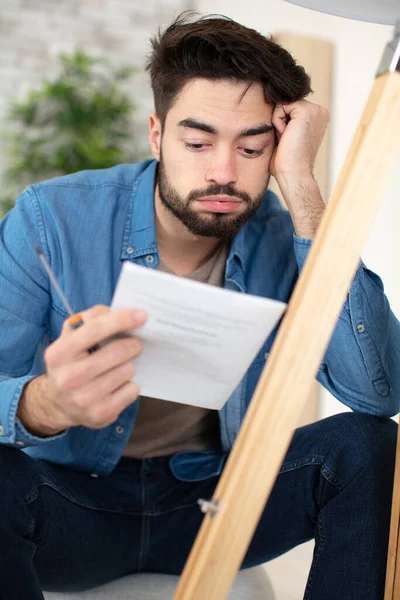 Frustrated Young Man Reading Instructions Assemble Furniture — Stock Photo, Image
