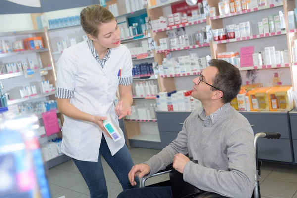 Freundliche Apothekerin Berät Behinderte Kunden Über Medikamentendosierung — Stockfoto