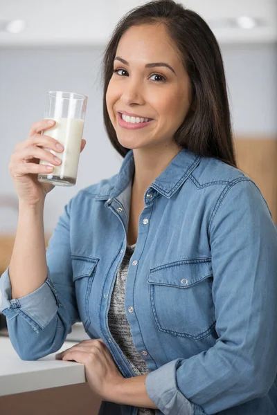 ガラスから牛乳を飲む幸せな女性は — ストック写真