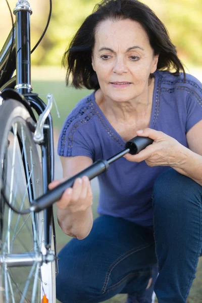 Starsza Kobieta Myje Rower Zewnątrz — Zdjęcie stockowe