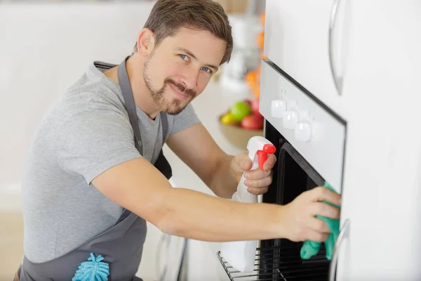 Mann Mit Tuchreinigung Ofen Der Heimischen Küche — Stockfoto