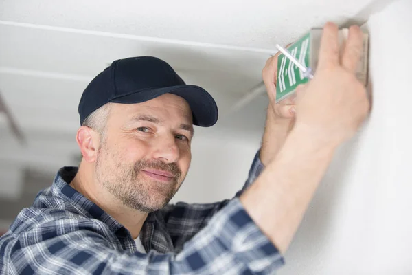 Ein Männlicher Arbeiter Und Ein Notausgangsschild — Stockfoto