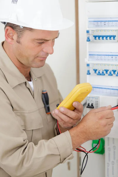 Male Electrician Using Multimeter Fusebox — Stock Photo, Image