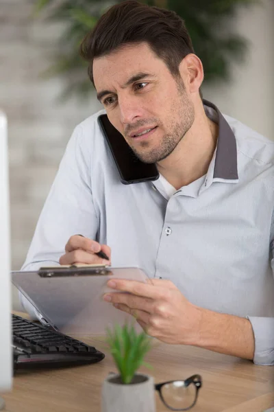 Hombre Negocios Guapo Está Tomando Notas Mientras Habla Por Teléfono —  Fotos de Stock